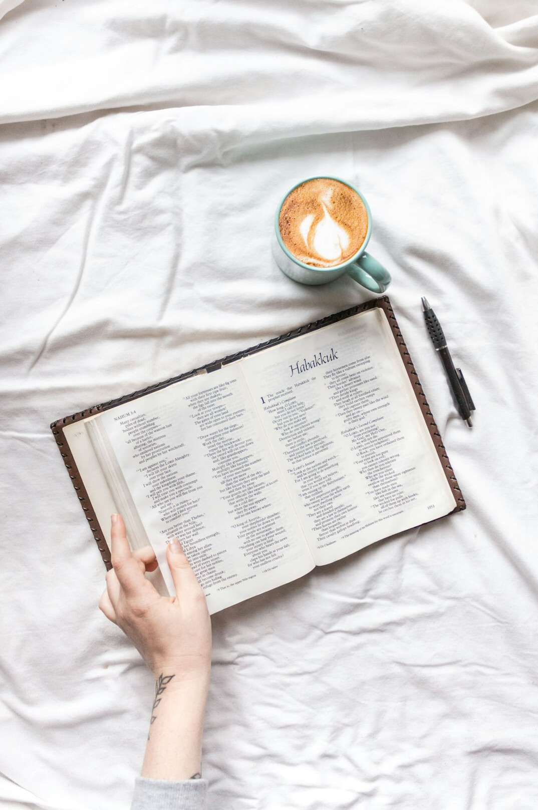Mãos escrevendo em um caderno de anotações sobre uma mesa de madeira