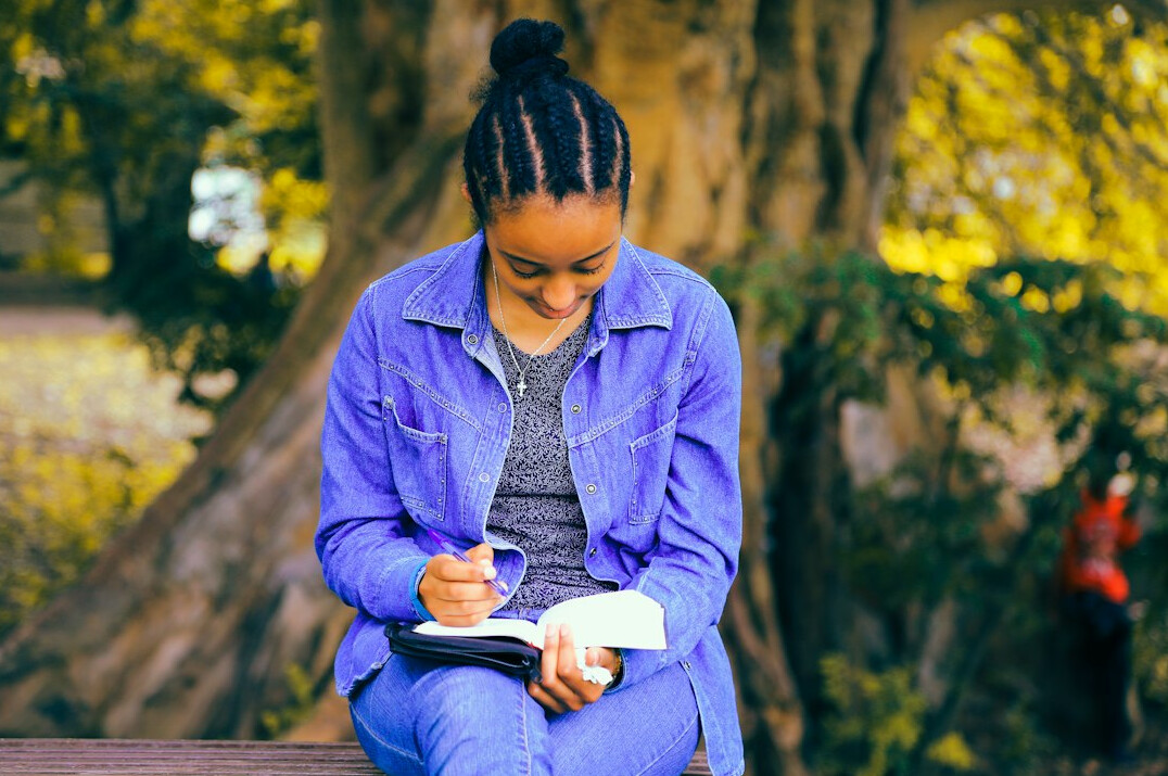 woman writing goals in planner